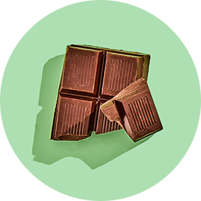 Four pieces of chocolate on a green background.